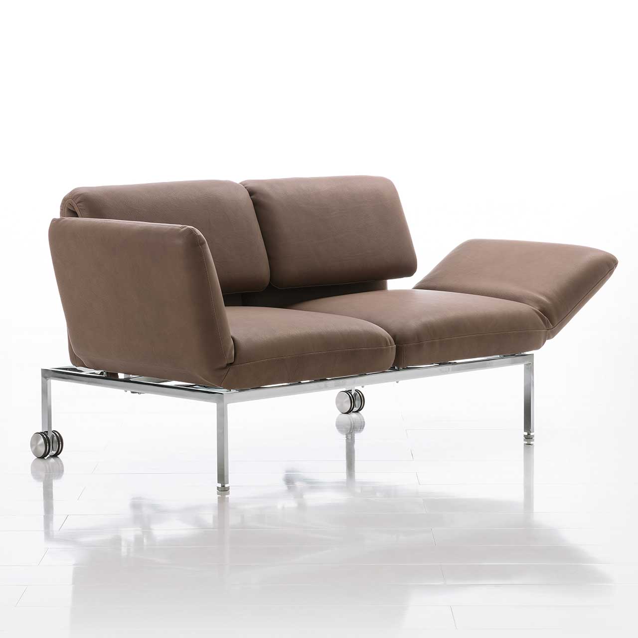 Zweisitziges Sofa der Serie roro small classic in braunem Leder. Armlehne rechts abgesenkt.