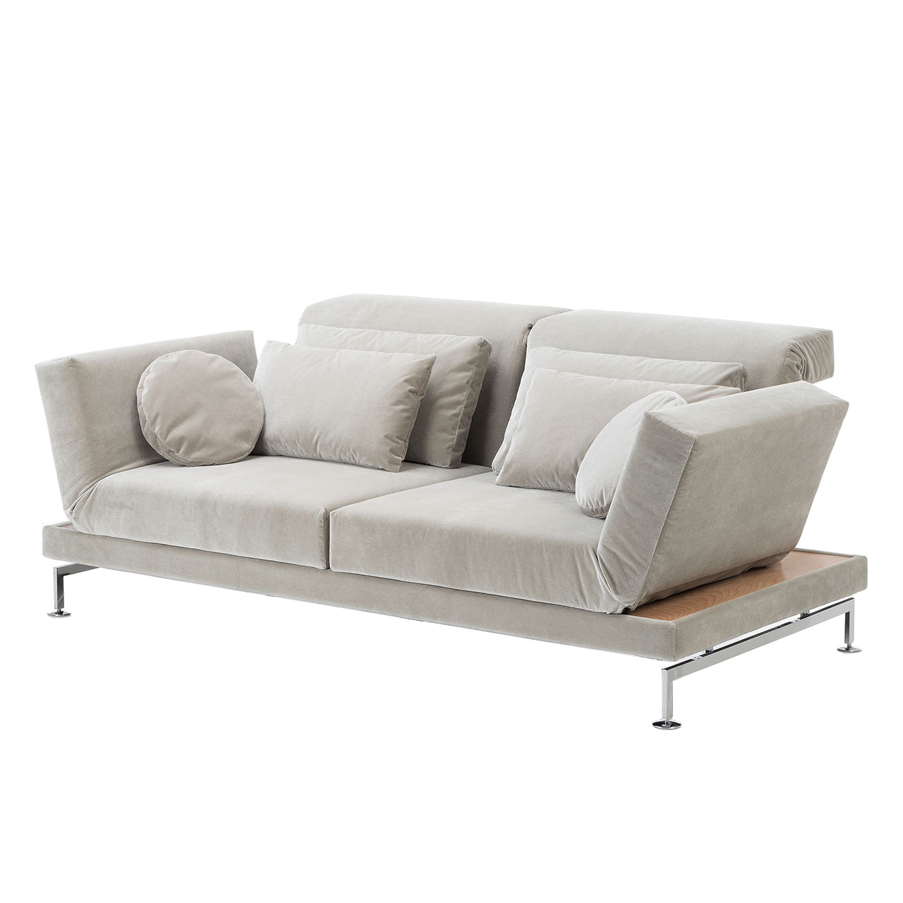 Beiges Sofa von brühl. Rechts und links neben den Armlehnen befinden sich schmale Ablageflächen in hellem Holz. Auf dem Sofa liegen vier rechteckige Kissen sowie zwei runde Kissen. Die Kufen sind chrom glänzend.
