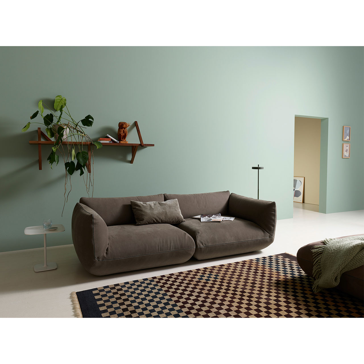 Zweisitzer-Sofa aus dunklem Leder dekoriert mit einem Kissen.
