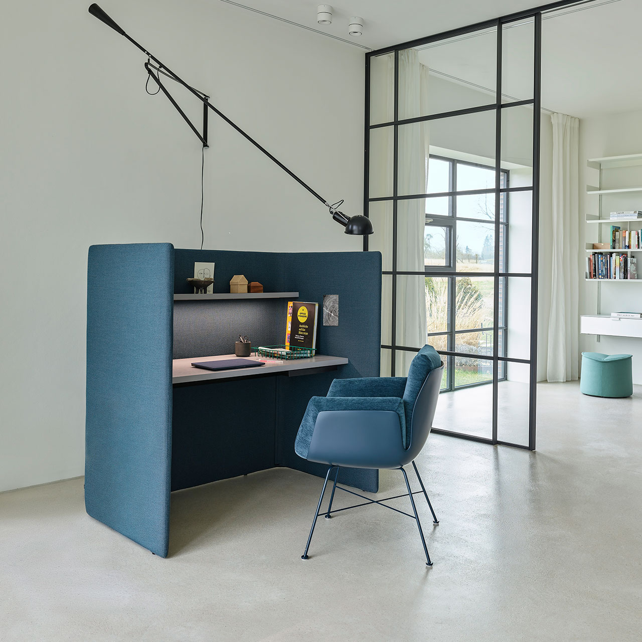 Stuhl mit blauer Schale und Drahtgestell vor einem blauen Homeoffice-Arbeitsplatz