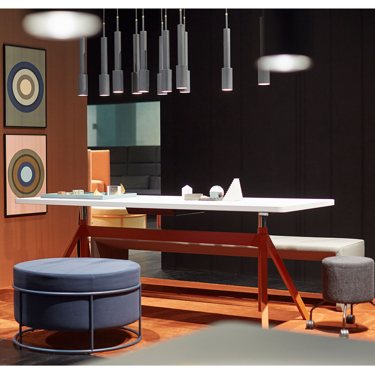 Weißer Tisch mit rotem Gestell in niedriger Position mit Bank und zwei Drop Hockern davor
