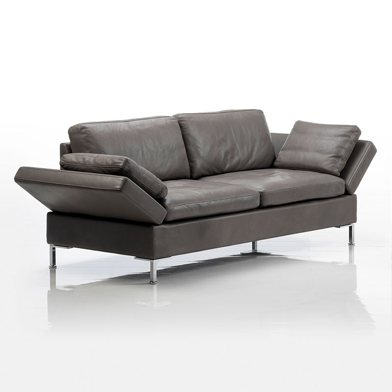 Lederbezogenes Sofa. Die Armlehnen sind auf beiden Seiten halb abgesenkt.