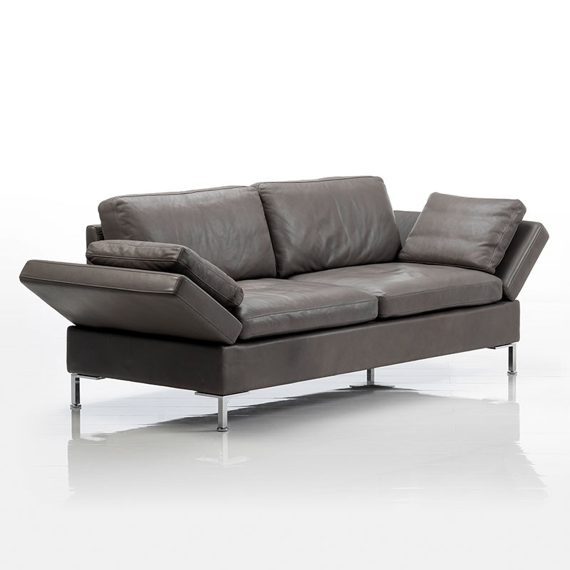 Lederbezogenes Sofa. Die Armlehnen sind auf beiden Seiten halb abgesenkt.