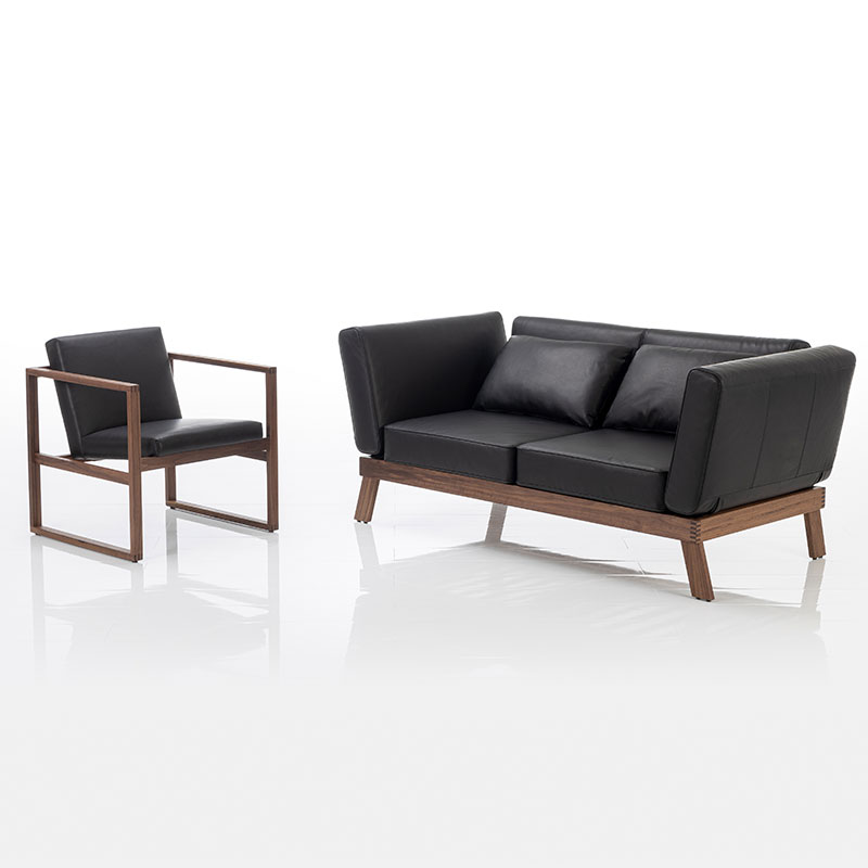Sofa der Serie brühl Lofoten und Sessel der Serie brühl grace wood in schwarzem Leder.