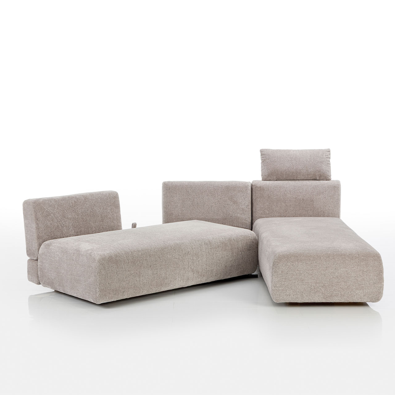 Bodennahes beiges Eckofa mit Drehsofa links und Longchair rechts. Das Drehsofa ist im 45 Grad Winkel zum Longchair vorgeschwenkt.