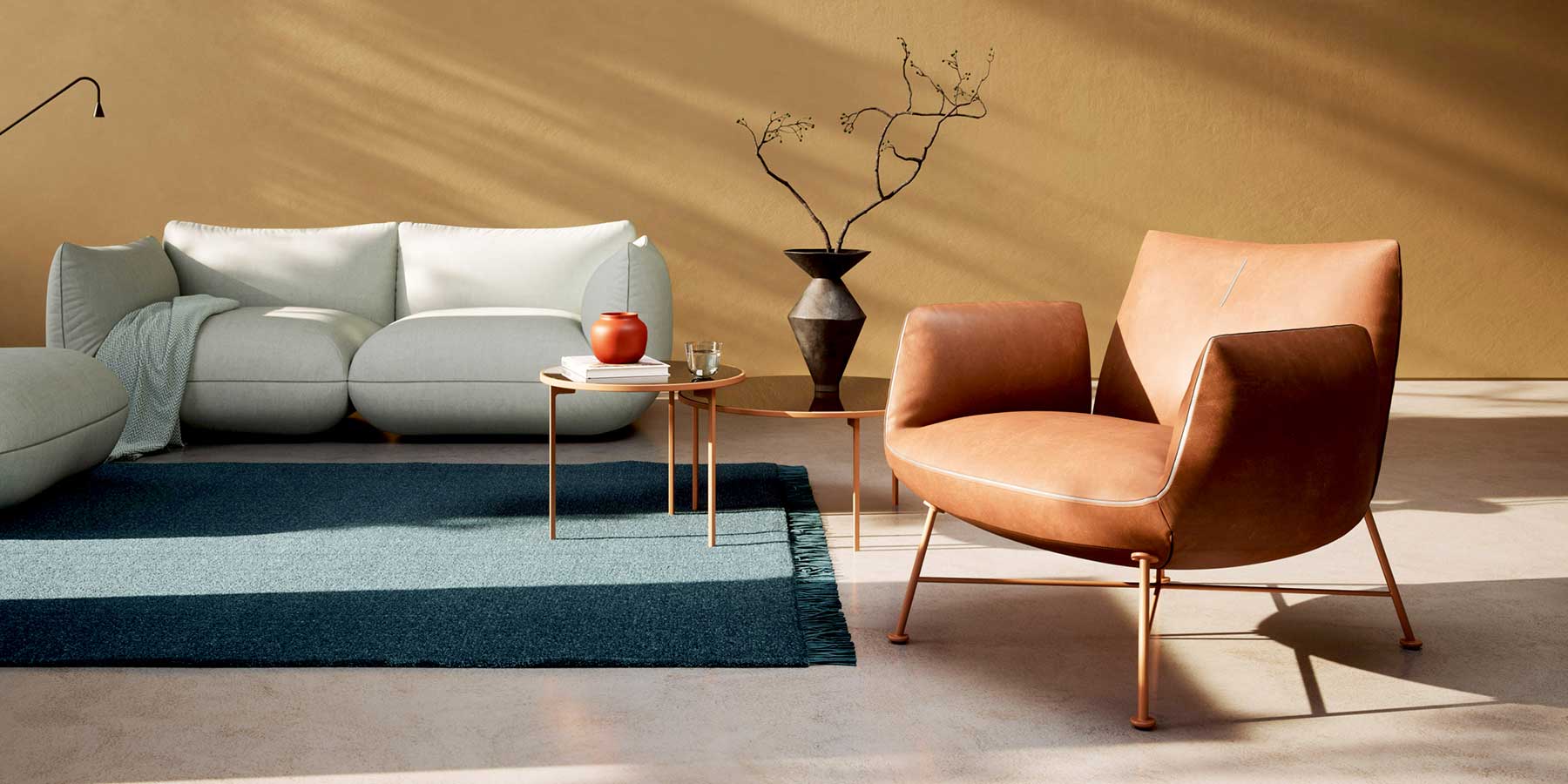 Links steht ein helles Jalis Sofa, rechts ein Clubsessel mit cognacfarbenem Leder bezogen.