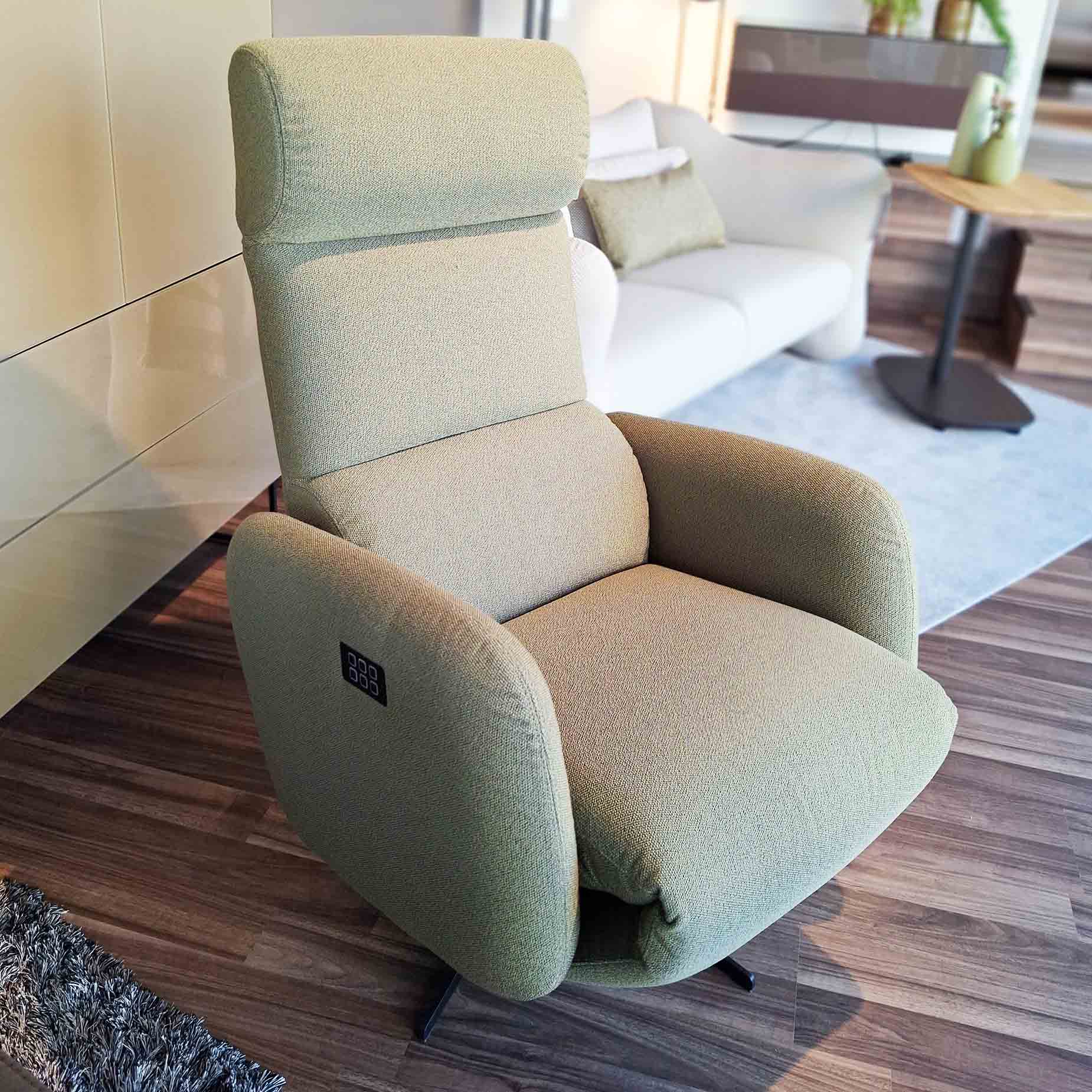 Relaxsessel in grünem Stoff mit Sternfuß.