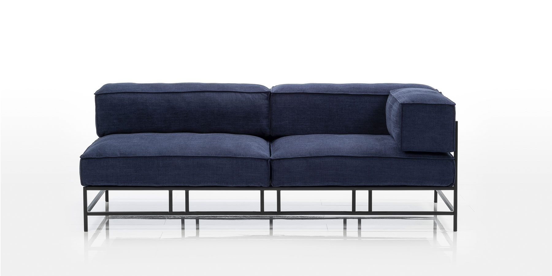 Ein Openend aus opulenten Polstern auf einem filigranen schwarzen Metallgestell.