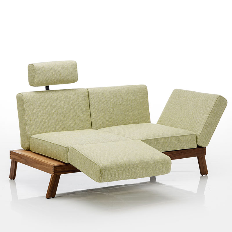 Sofa mit Bezug in der Farbe Limette, das Untergestell ist aus dunkler Eiche.