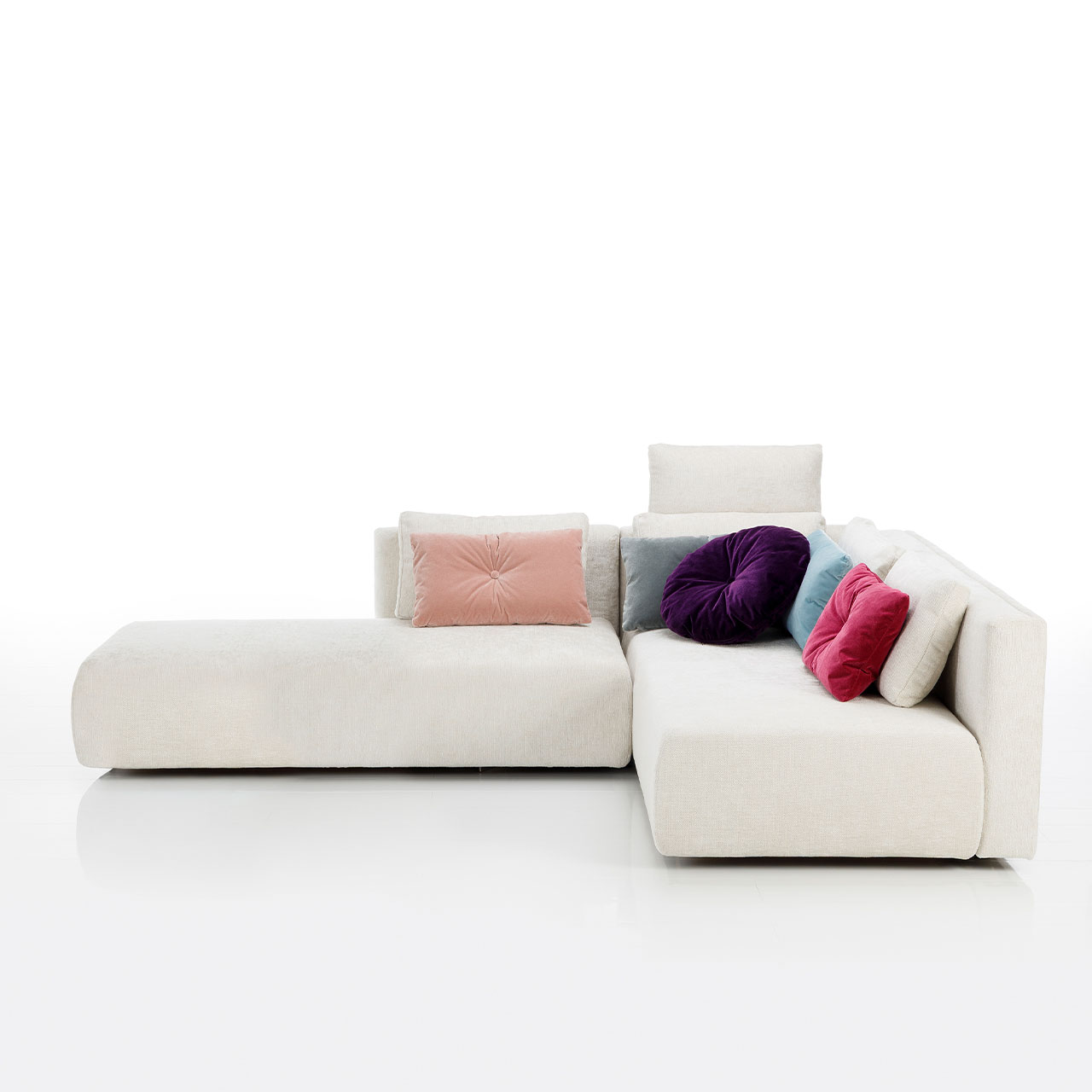 Bodennahes weißes Eckofa mit Drehsofa rechts und Longchair links.