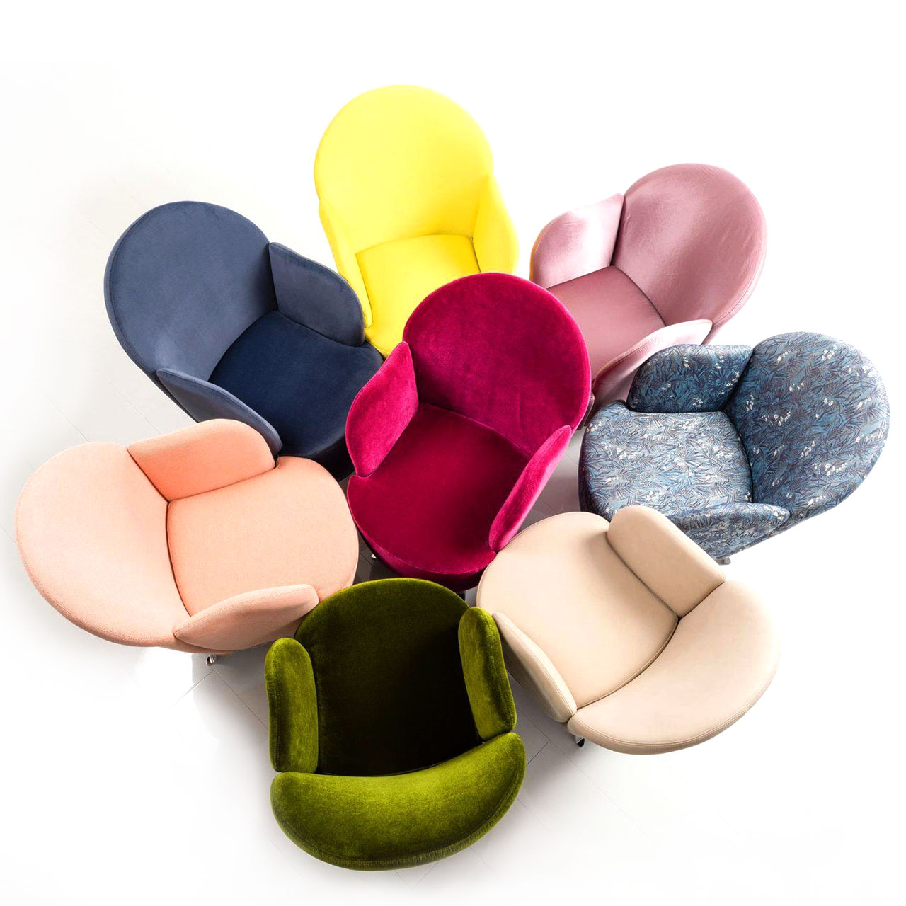 Acht Sessel der Serie floret stehen blütenförmig angeordnet beieinander. Die Sessel sind alle mit unterschiedlichen Stoffen bezogen.