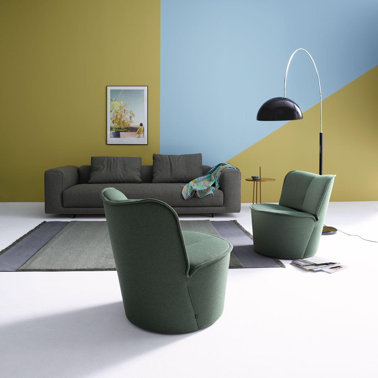 Graues Sofa kombiniert mit zwei grünen Nenou-Sesseln im Wohnzimmer