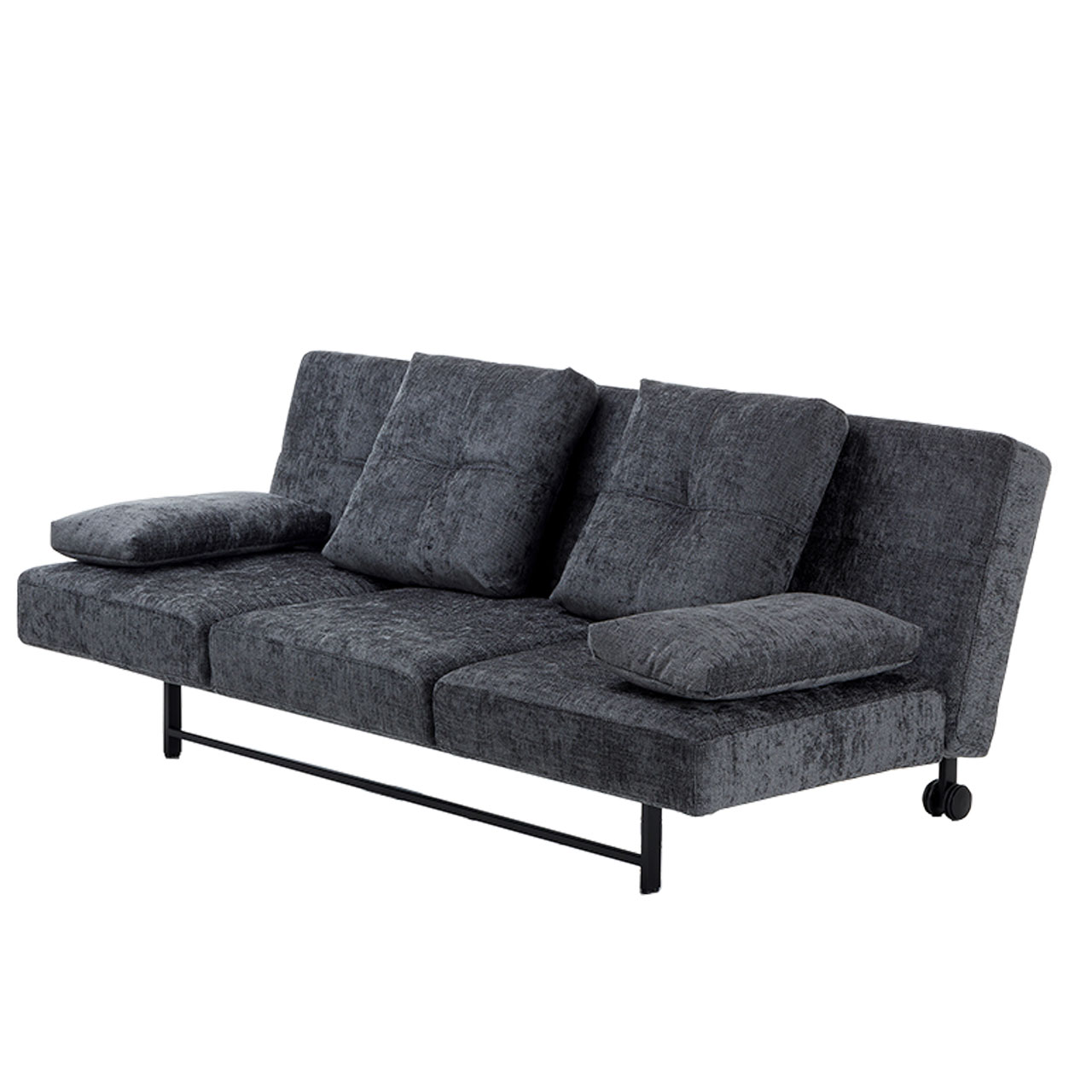 Leicht schräge Sicht auf ein Sofa in anthrazit. Das Sofa steht auf einem schwarzen Metallgestell mit Rollen an den hinteren Füßen. Auf dem Sofa stehen zwei große quadratische Kissen und an den Seiten liegen zwei kleinere, rechteckige Kissen als Armlehnen.
