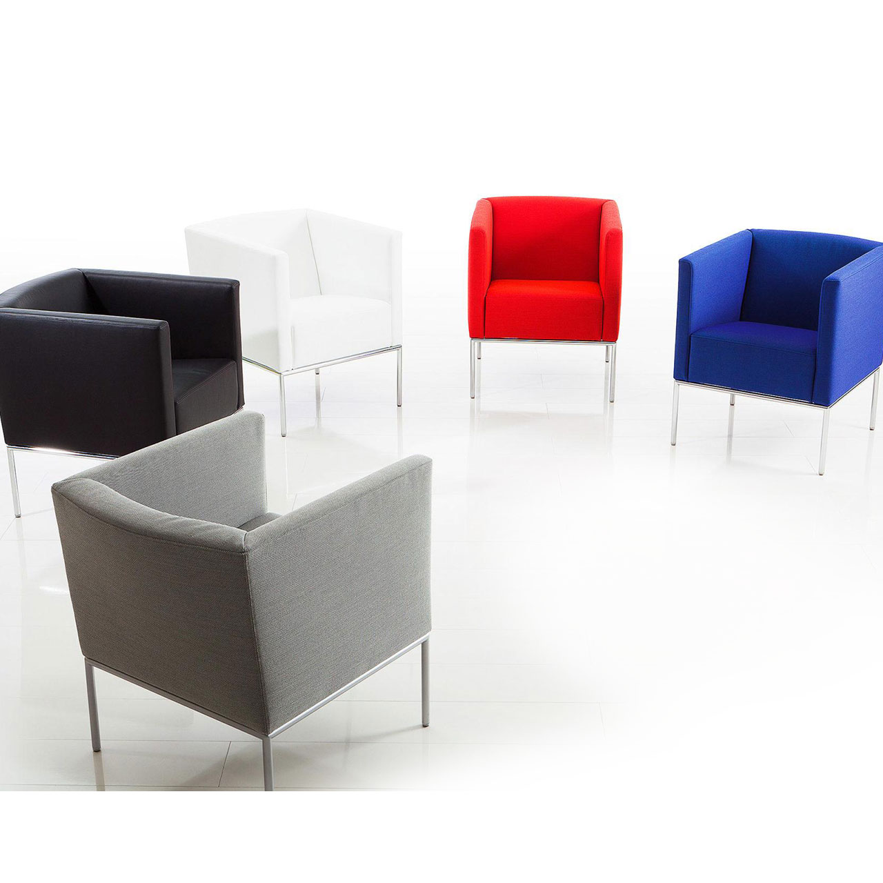 Eine Gruppe aus fünf Sesseln in den Farben grau, schwarz, weiß, rot und blau stehen im Halbkreis zusammen.