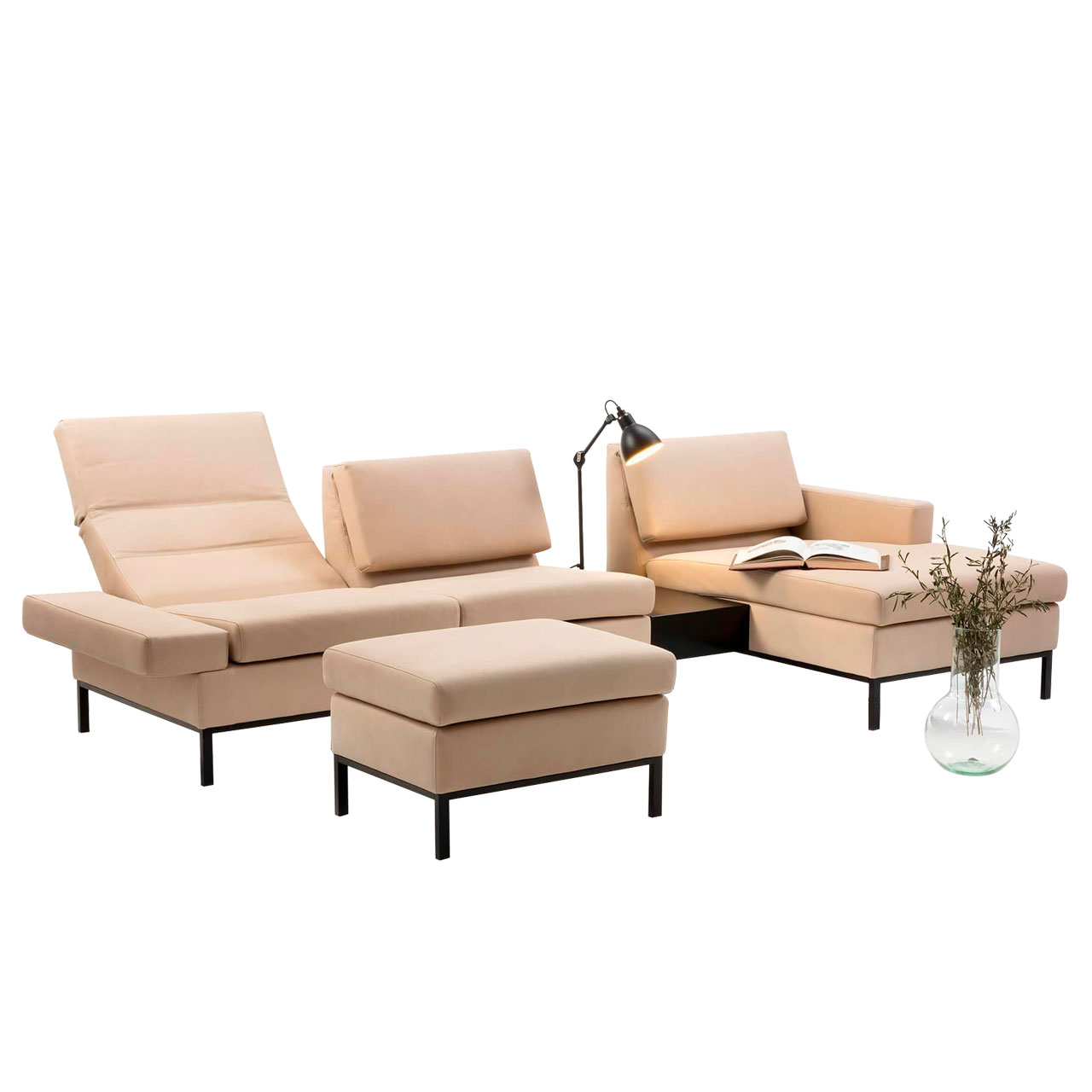 Eckgarnitur mit Longchair links und Einhängetisch. Vor dem Anstellsofa steht eine Fußbank. Die Polstermöbel sind in beigem Leder mit Untergestellen in schwarz.