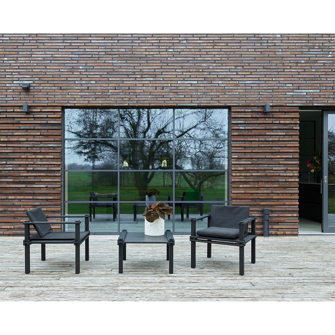 Bild zwei schwarzer Stühle mit passendem Tisch auf einer Terrasse