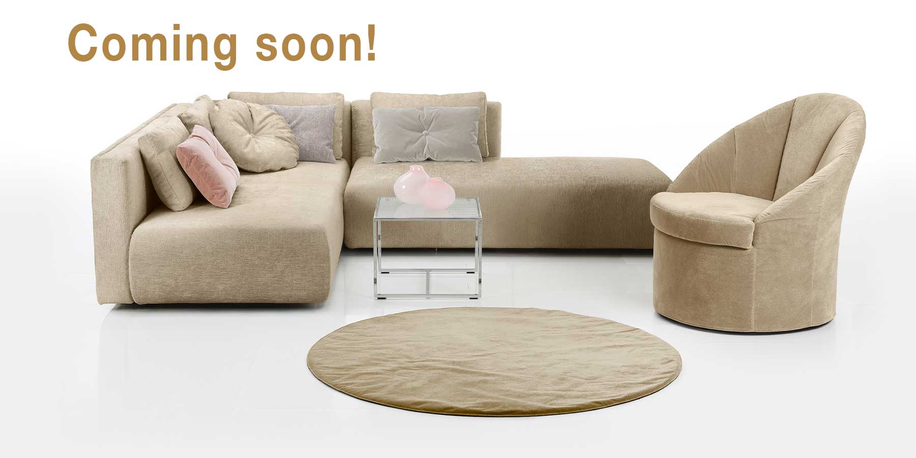 Ein beiges Ecksofa mit Sessel rechts. Davor liegt ein runder, beiger Teppich.