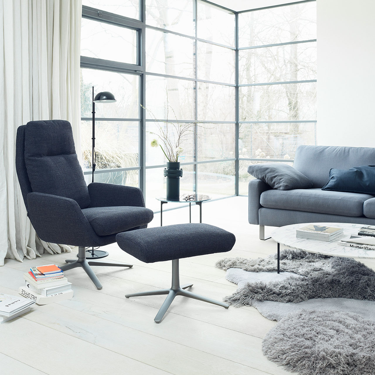 Cordia Sessel mit passenden Hocker im Wohnzimmer