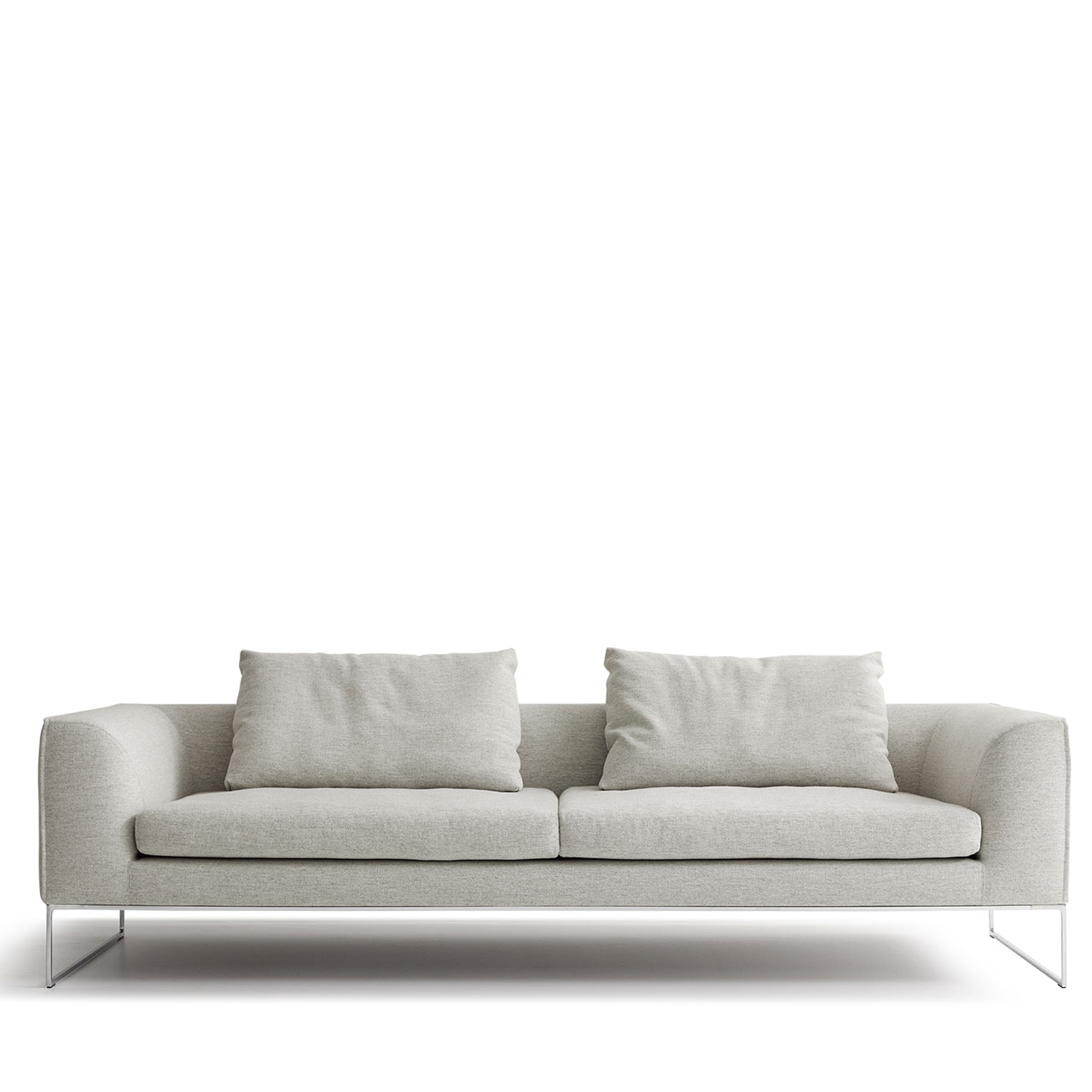 Graues Sofa auf Chromkufen mit zwei Sitzkissen und zwei Rückenkissen.