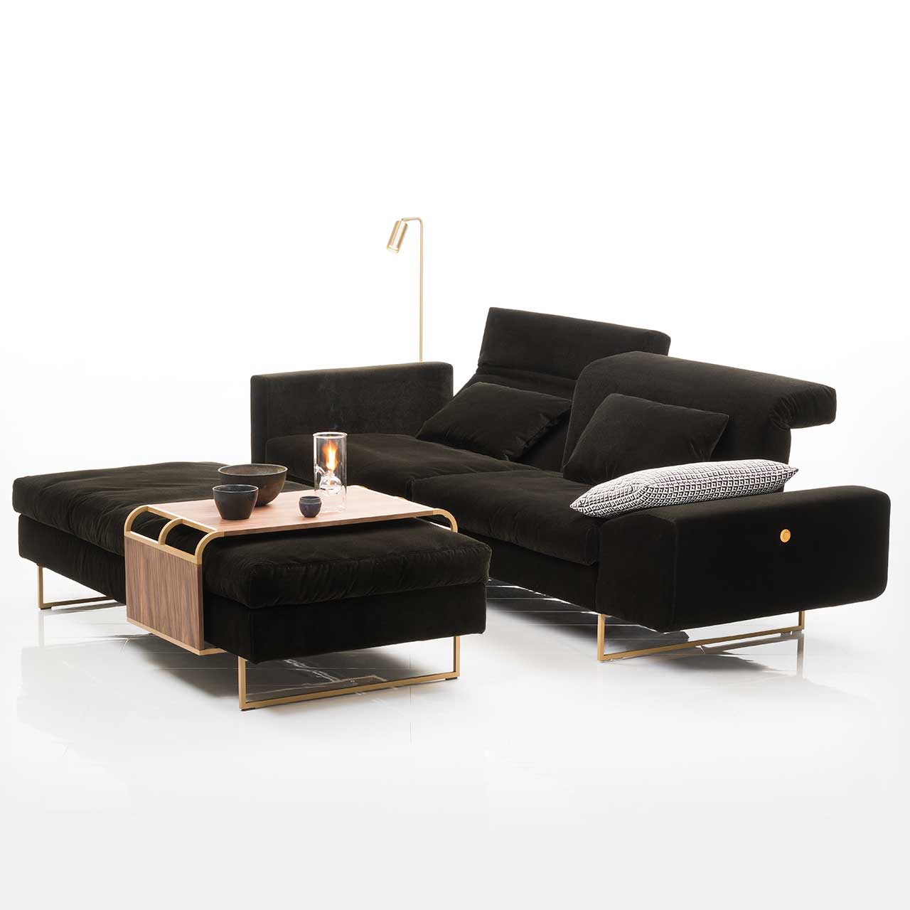 Ambientebild: brühl embrace asymmetrisches Sofa. Davor stehen eine Bank mit aufgelegtem verschiebbarem Tisch.