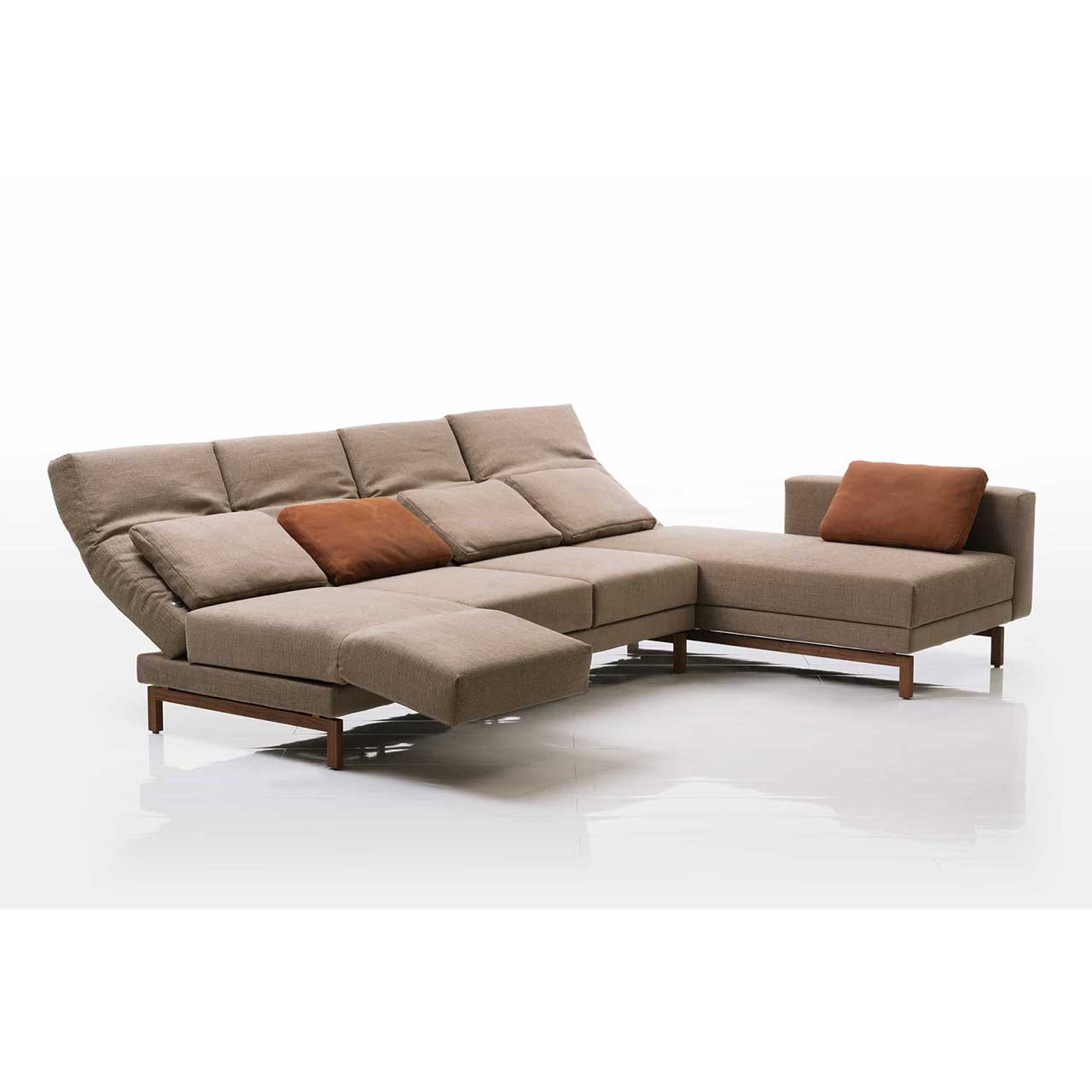 Eckgarnitur in hellbraunem Stoff mit Longchair rechts. Die Armlehne des Longchairs ist bis zum Fußende vorgeschoben. Die Rückenlehnen sind alle halb abgesenkt. Die linke Armlehne ist zur Relaxposition vorgeschwenkt. 