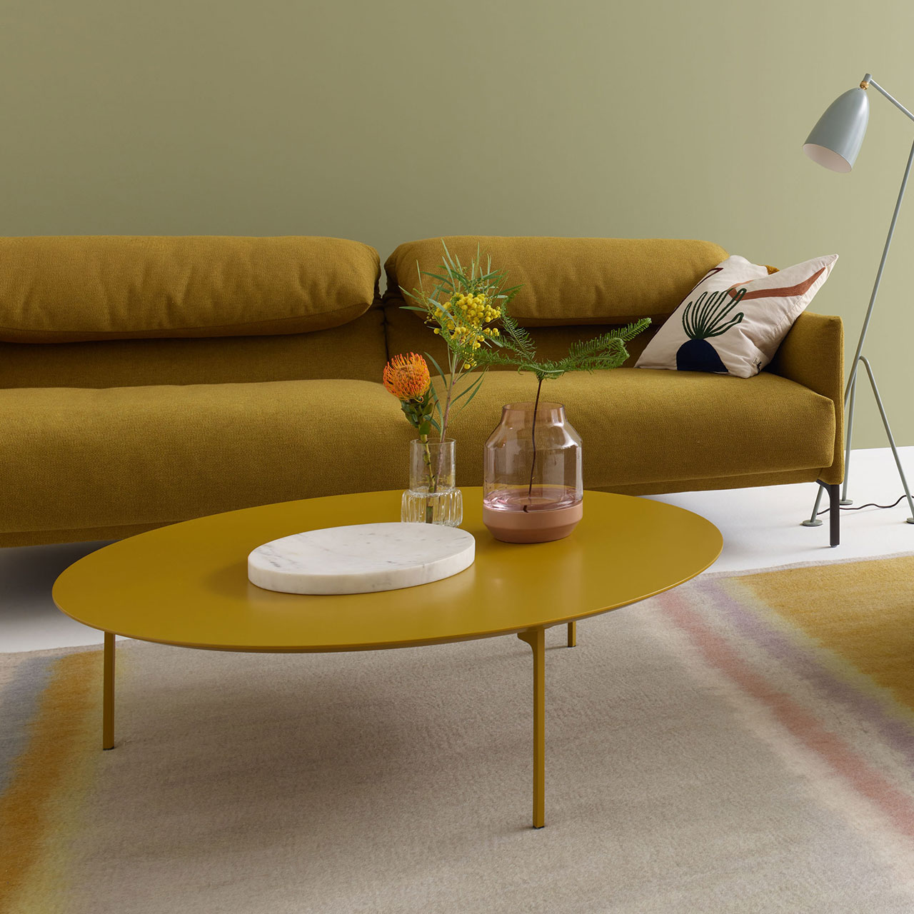 Couchtisch mit gelber MDF-Tischplatte vor passender Couch