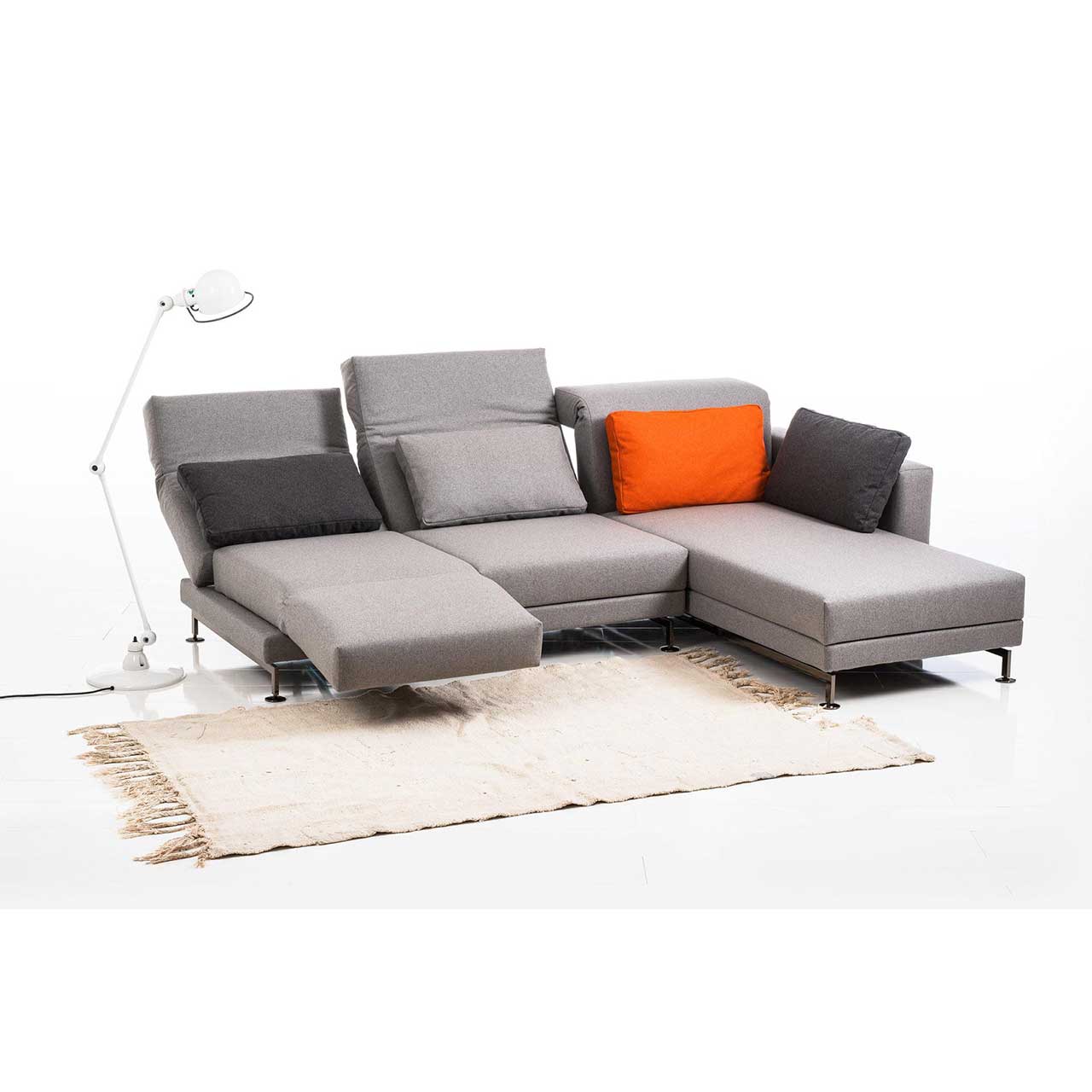 Eckgarnitur in grauem Stoff mit Longchair rechts. Der linke Sitzplatz ist zur Relaxposition umgebaut.