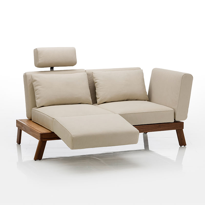 Sofa mit Bezug in der Farbe Beige, das Untergestell ist aus dunkler Eiche.