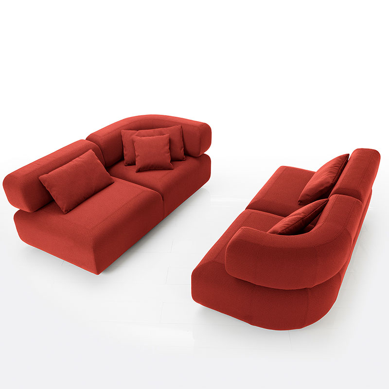 Zwei Openends mit geschwungenen Armlehnen stehen sich einander gegenüber. Der Stoff ist rot.