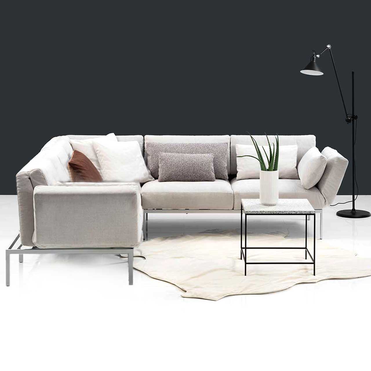 Eckgarnitur der Serie roro medium classic mit zwei Anstellsofas und einem Eckelement in cremefarbenem Stoff.