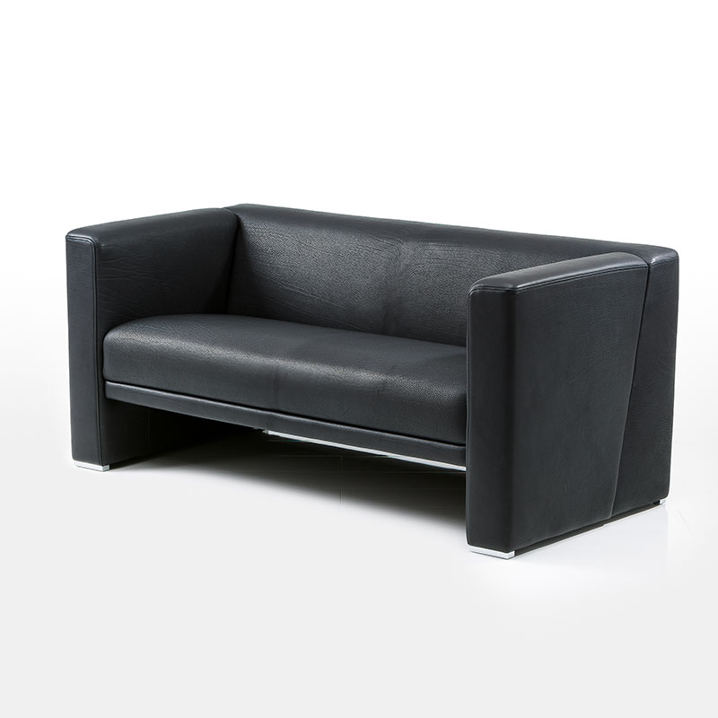 Schwarzes Ledersofa. Armlehnen und Rückenlehnen sind gleich hoch. Das Sofa ist sehr eckig geformt.