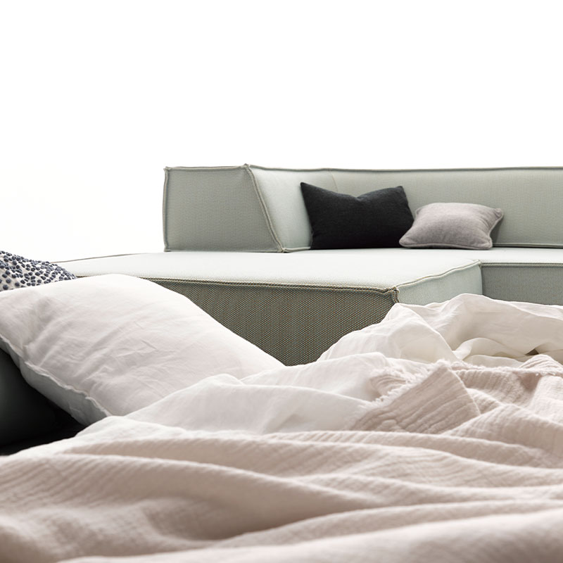 Blick auf ein Sofa von COR. Darauf drapiert liegen mehrere Kissen.