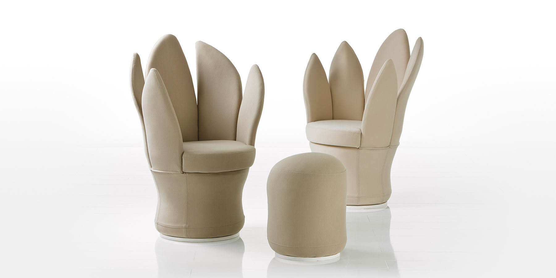 Zwei Sessel und ein Hocker in Beigem Leder. Die Seiten und die Rücken der Sessel bestehen aus ingesamt fünf länglichen Blattsegmenten.
