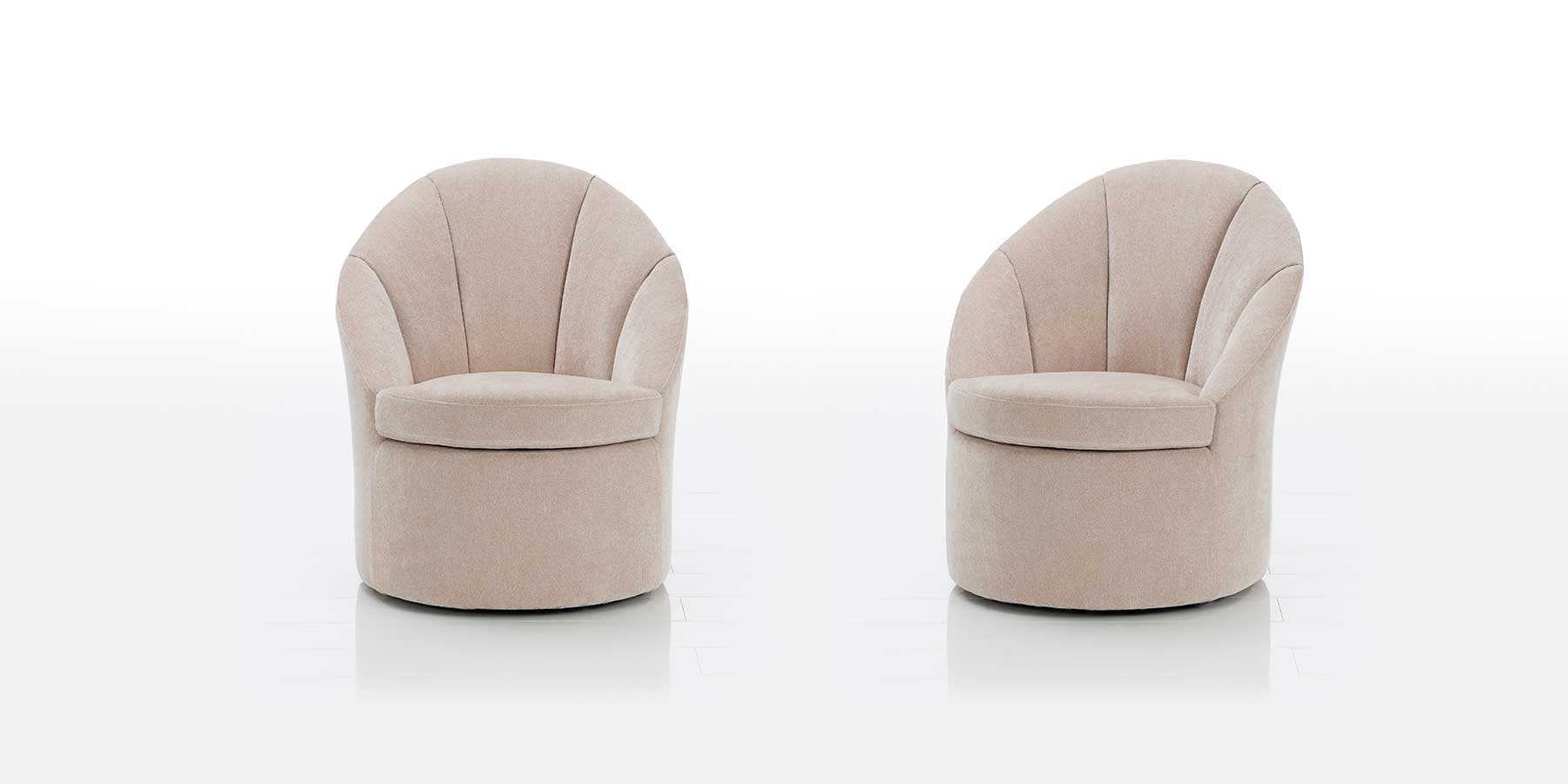 Zwei cremeweiße Sessel mit runder Sitzbasis. Die Sessel sind bodentief. Die Lehnen sind gerundet.