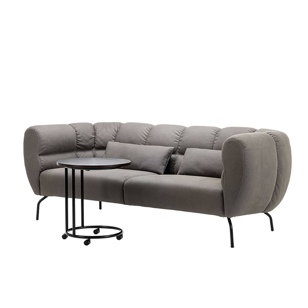 Sofa der Serie brühl magnolia in grauem Stoff mit schwarzen Metallfüßen. Davor steht ein Beistelltisch mit runder Platte und Rollen.
